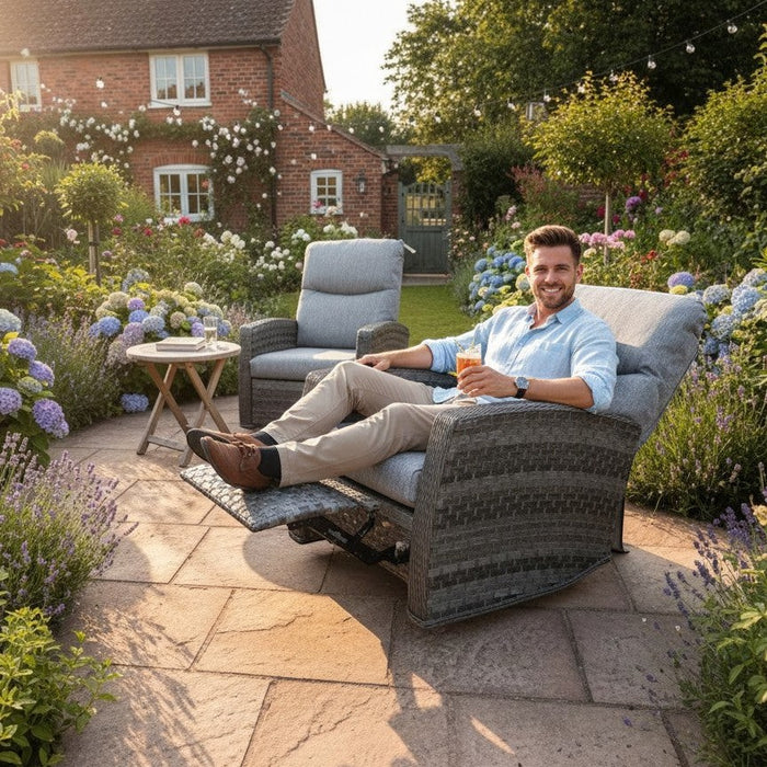 Man relaxing on a Mid Ulster Garden Centre Amalfi recliner chair in a lush garden with a matching bistro table.