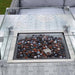 Mid Ulster Garden Centre Amalfi dark grey rattan dining table with integrated glass-protected gas firepit and stones.