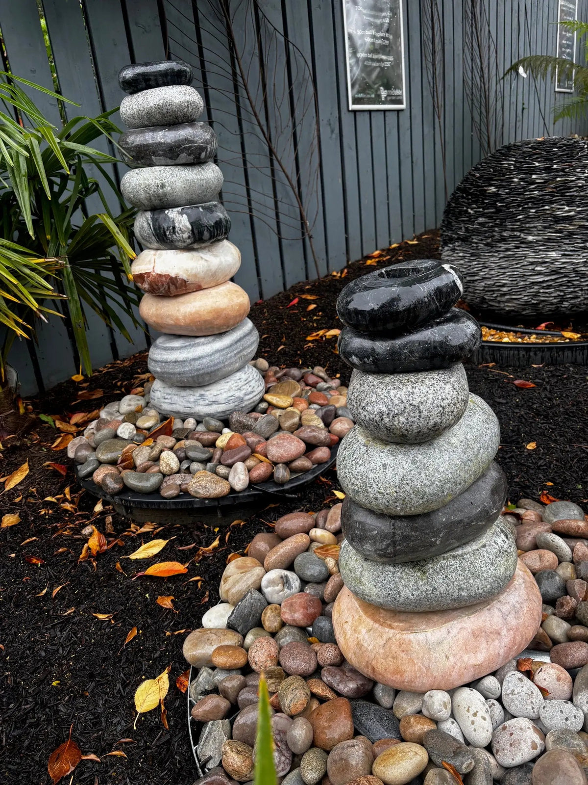 Mid Ulster Garden Centre cascading marble pebble fountain featuring stacked boulders in a garden setting.